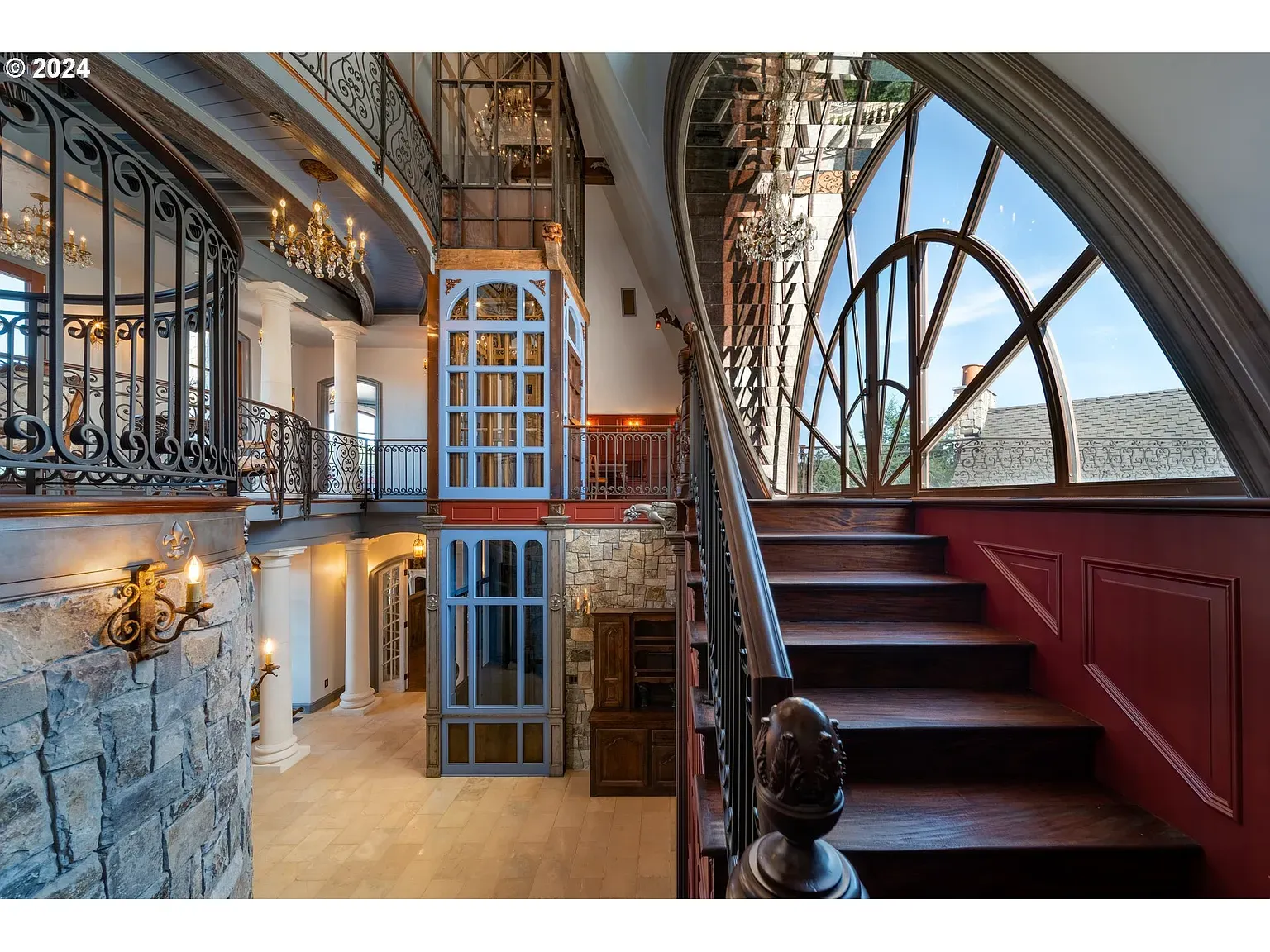 Okay, this elevator—blue steel and glass next to carved wood stairs. Why blue?