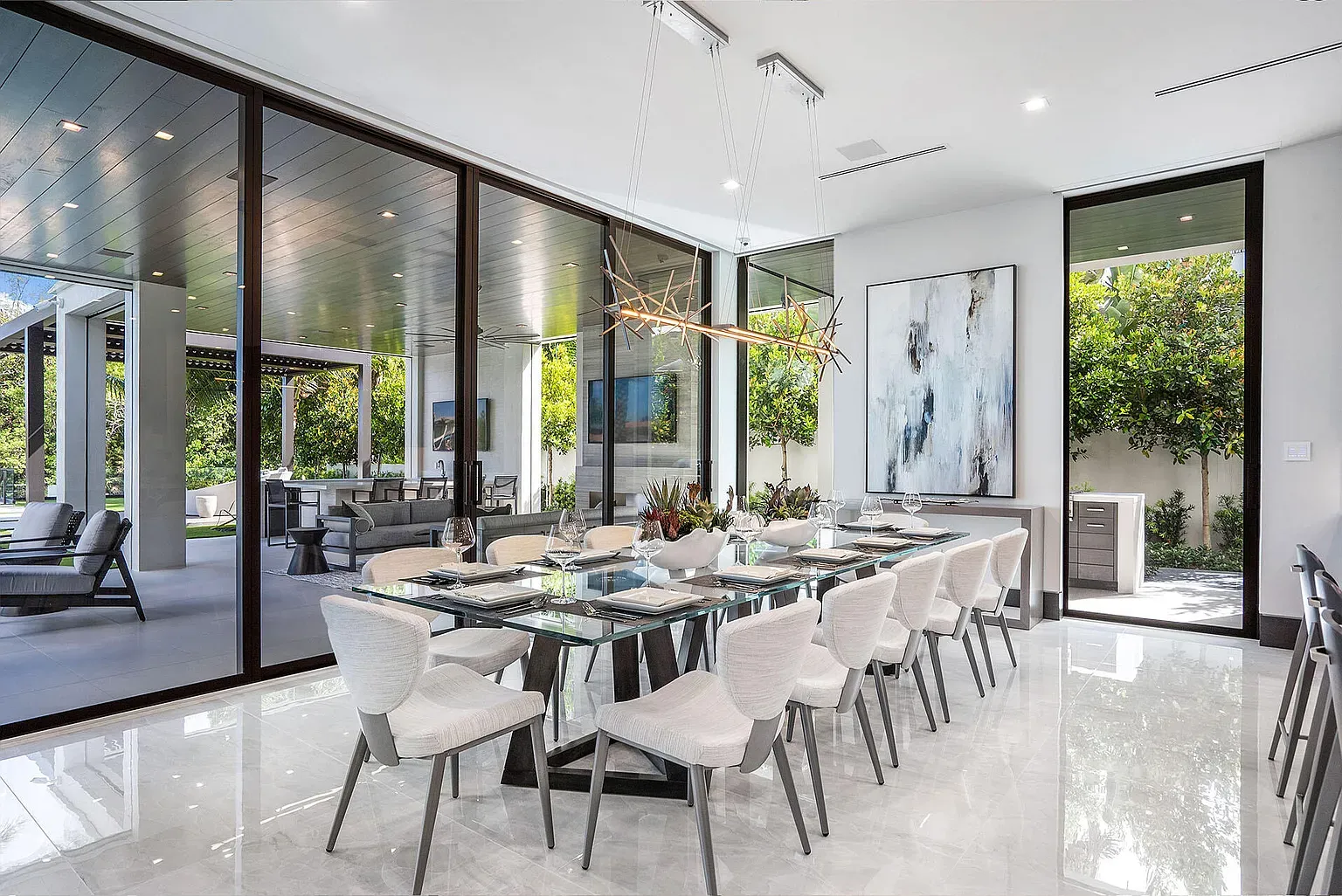 Dining setup is crisp—glass top, white chairs, all light and airy.