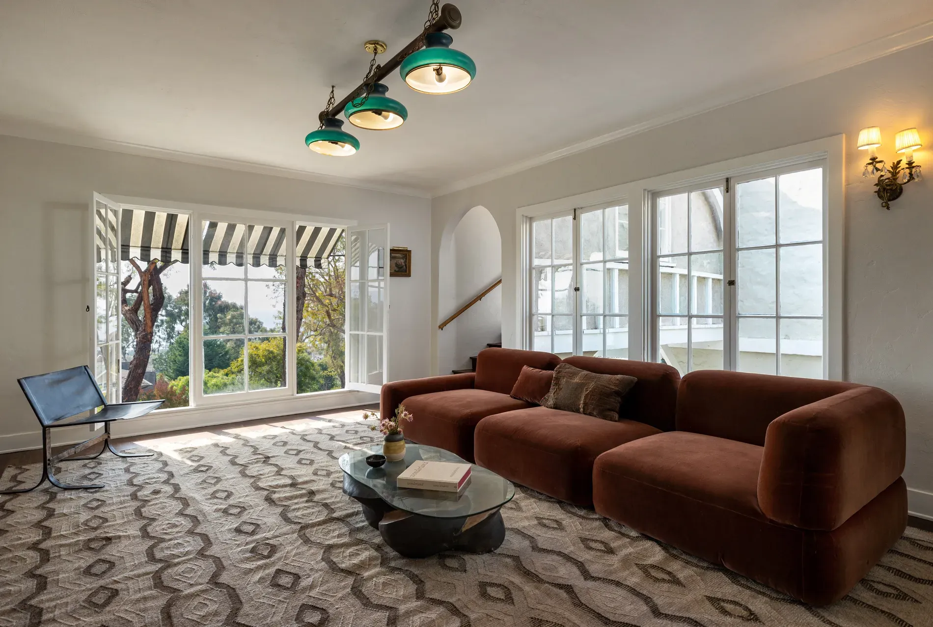 Okay, this sofa — bold orange curve. Kinda love it? Glass table keeps airy.
