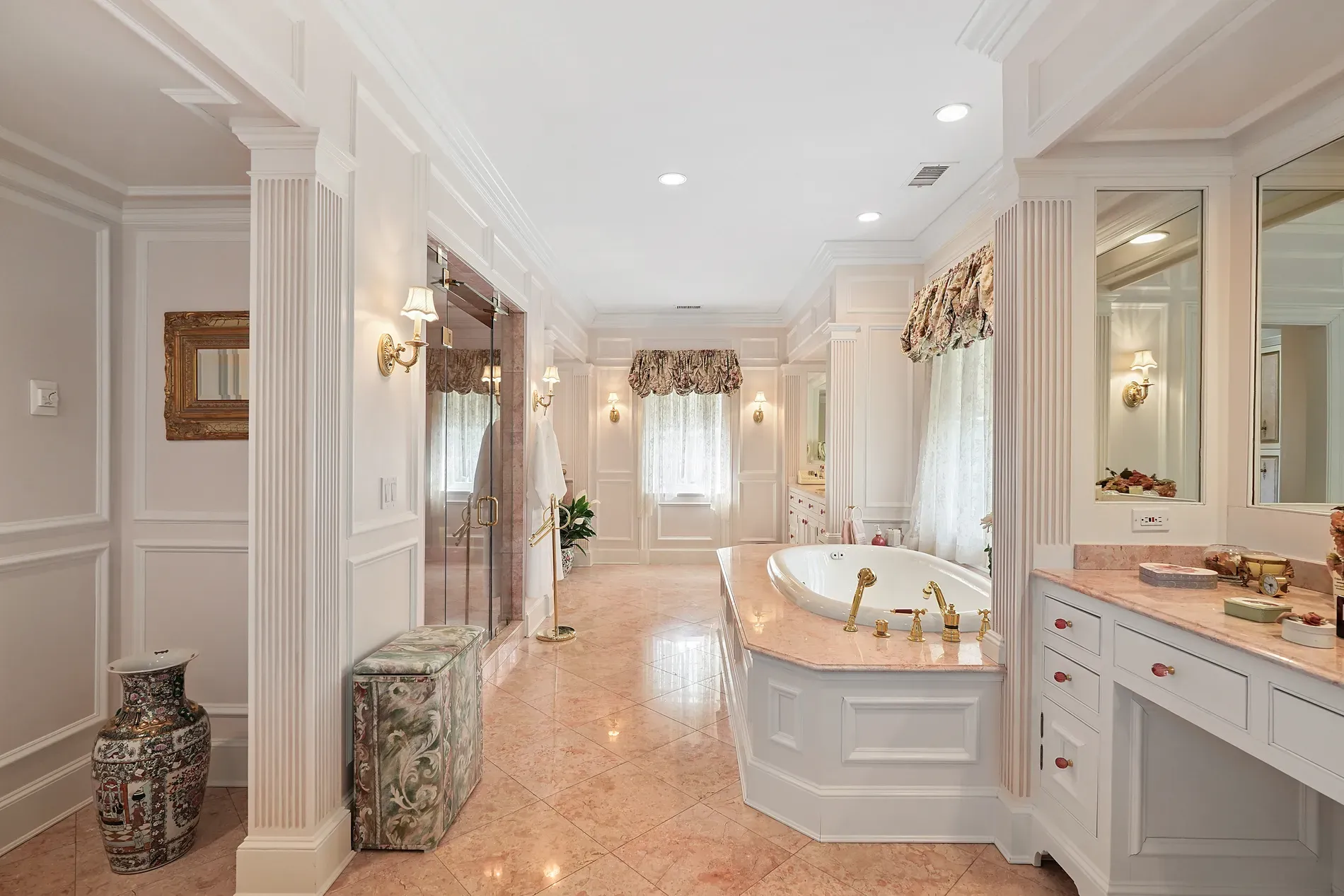 Bathroom’s peach marble floors, lacey windows — kind of sweet, kind of hotel.