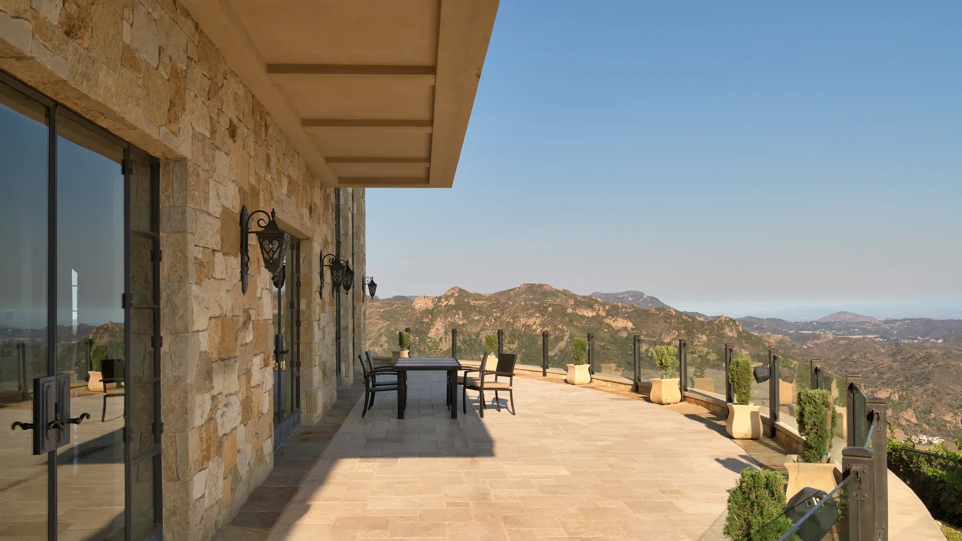 Here's the final terrace—warm stone, huge glass doors. Lines look super clean.