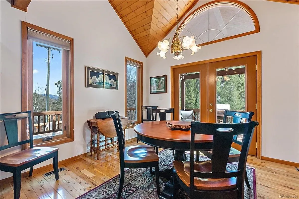 Round table with black chairs on a plush rug. Feels comfy, a touch formal.
