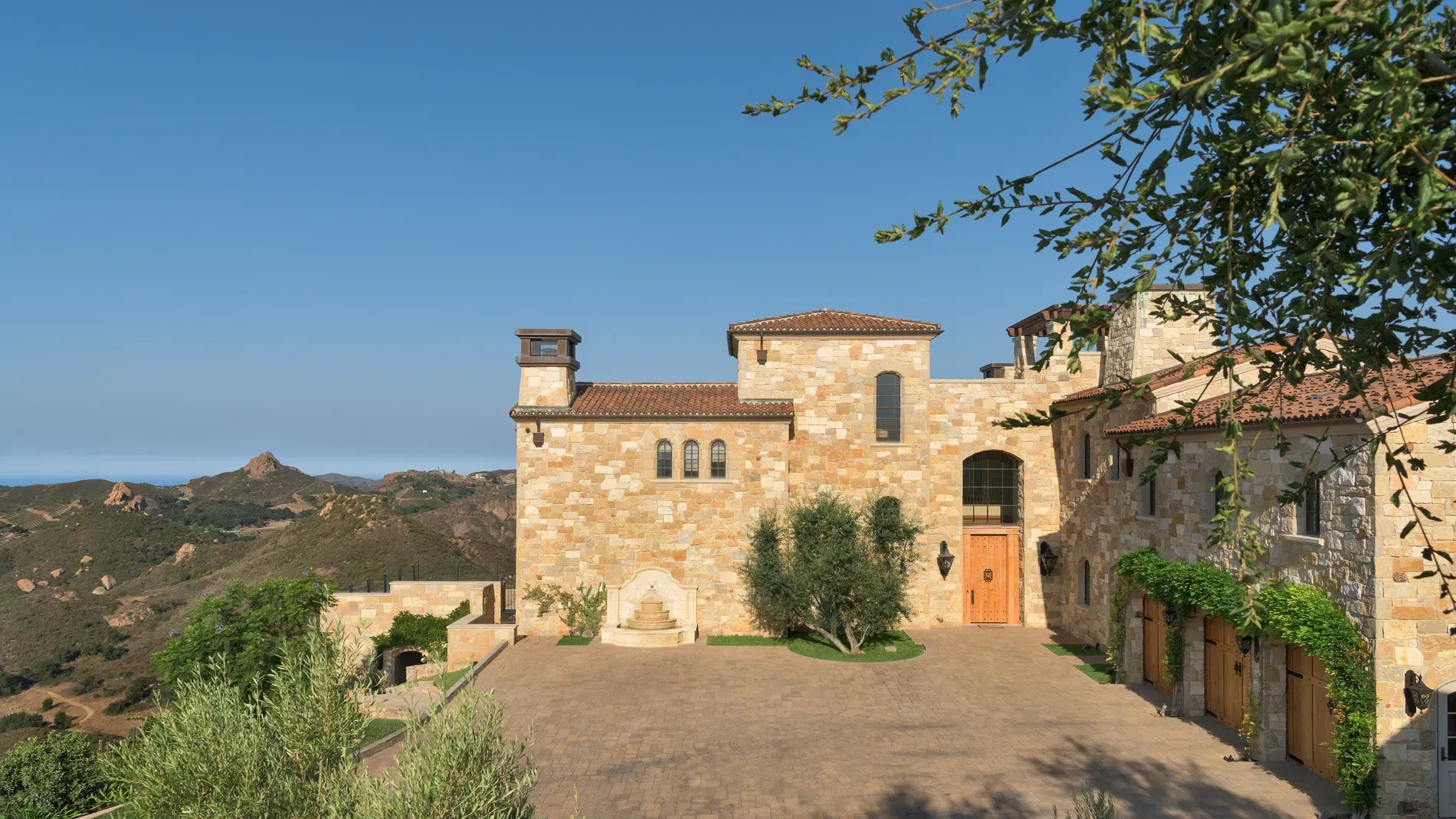 Honey-stone villa with a busy clay roofline. I mean, cool, maybe extra?