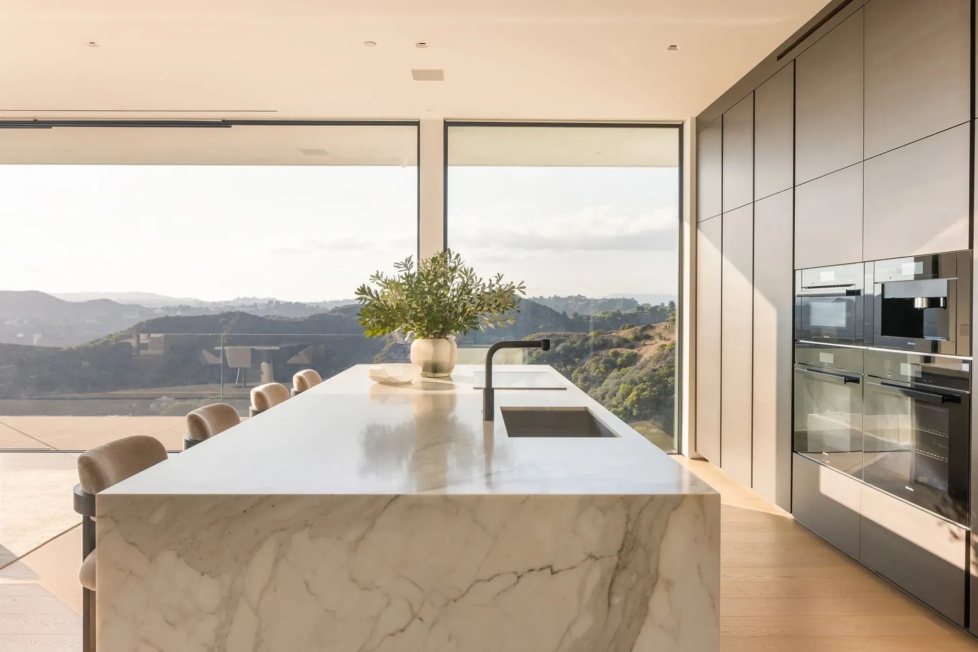 Here's the kitchen — giant marble slab says “chop elsewhere.” Hidden handles are slick.
