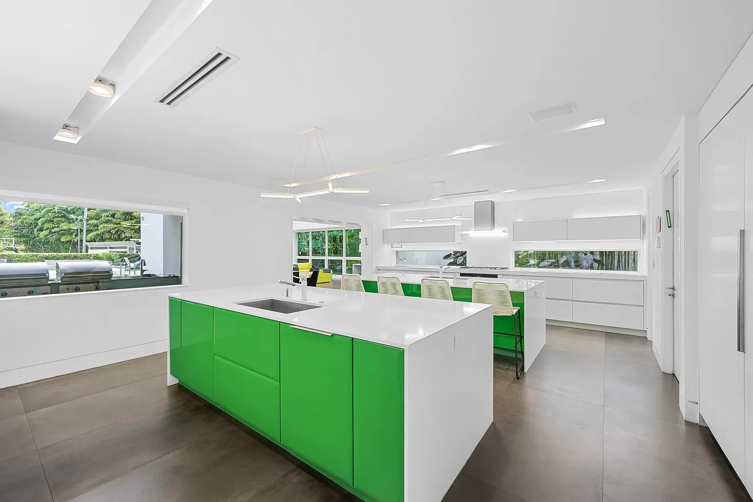 Here's the kitchen—white island, bold green cabinets. Brave choice, kinda loving it.