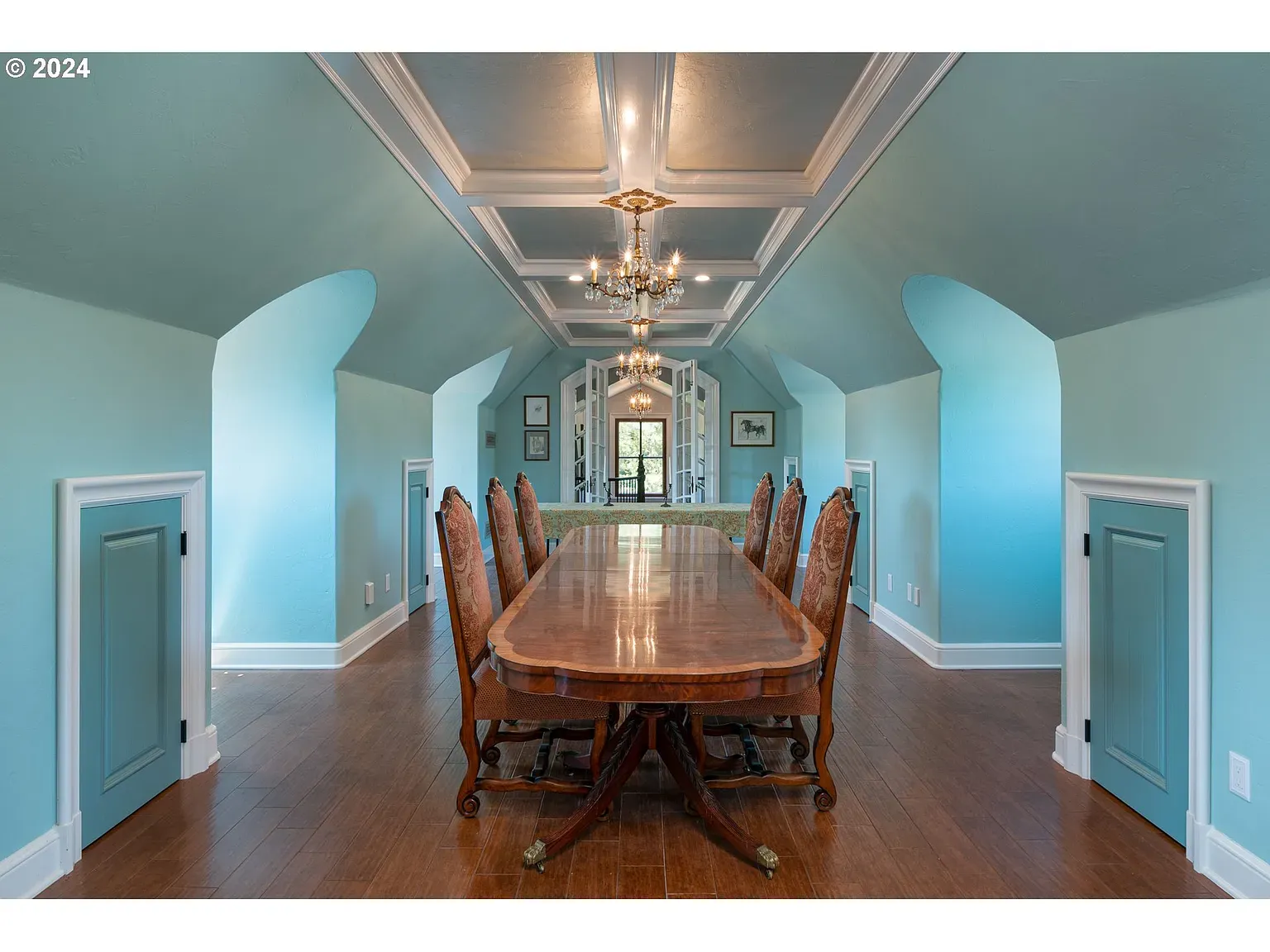 Coffered ceiling with sky-blue walls—super calm. Big chandelier pulling everything together.