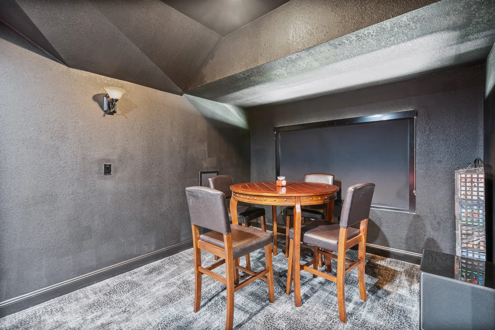 Small lounge vibe—charcoal walls, sloped ceiling. Game night spot for sure.