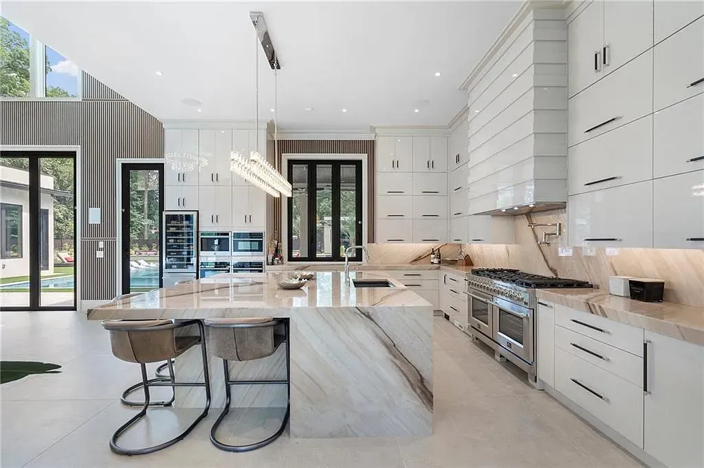 Glossy white kitchen, gold pulls everywhere. The island's begging for a brunch.