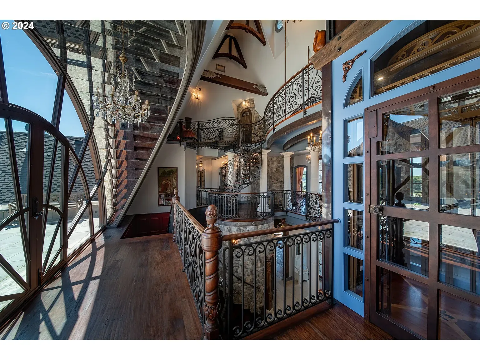 Grand entry—vaulted beams and a fancy iron balcony. Dramatic in a good way.