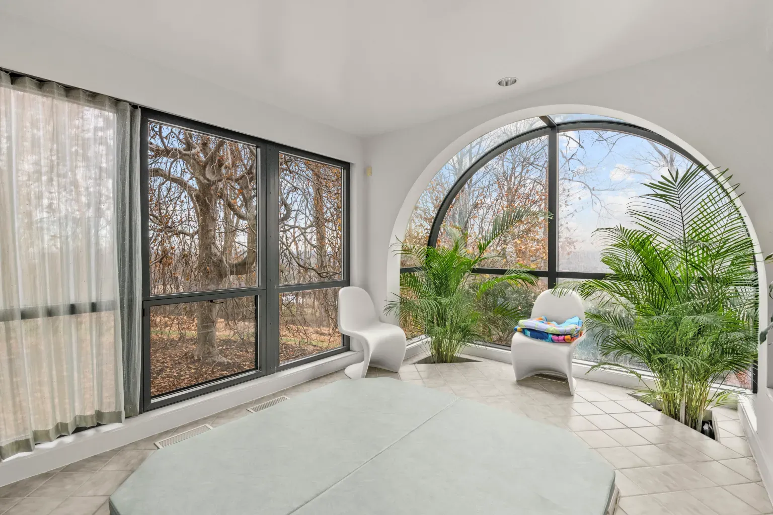 Sunroom flex. giant arches, curved chairs, blinding light. Do people nap here?