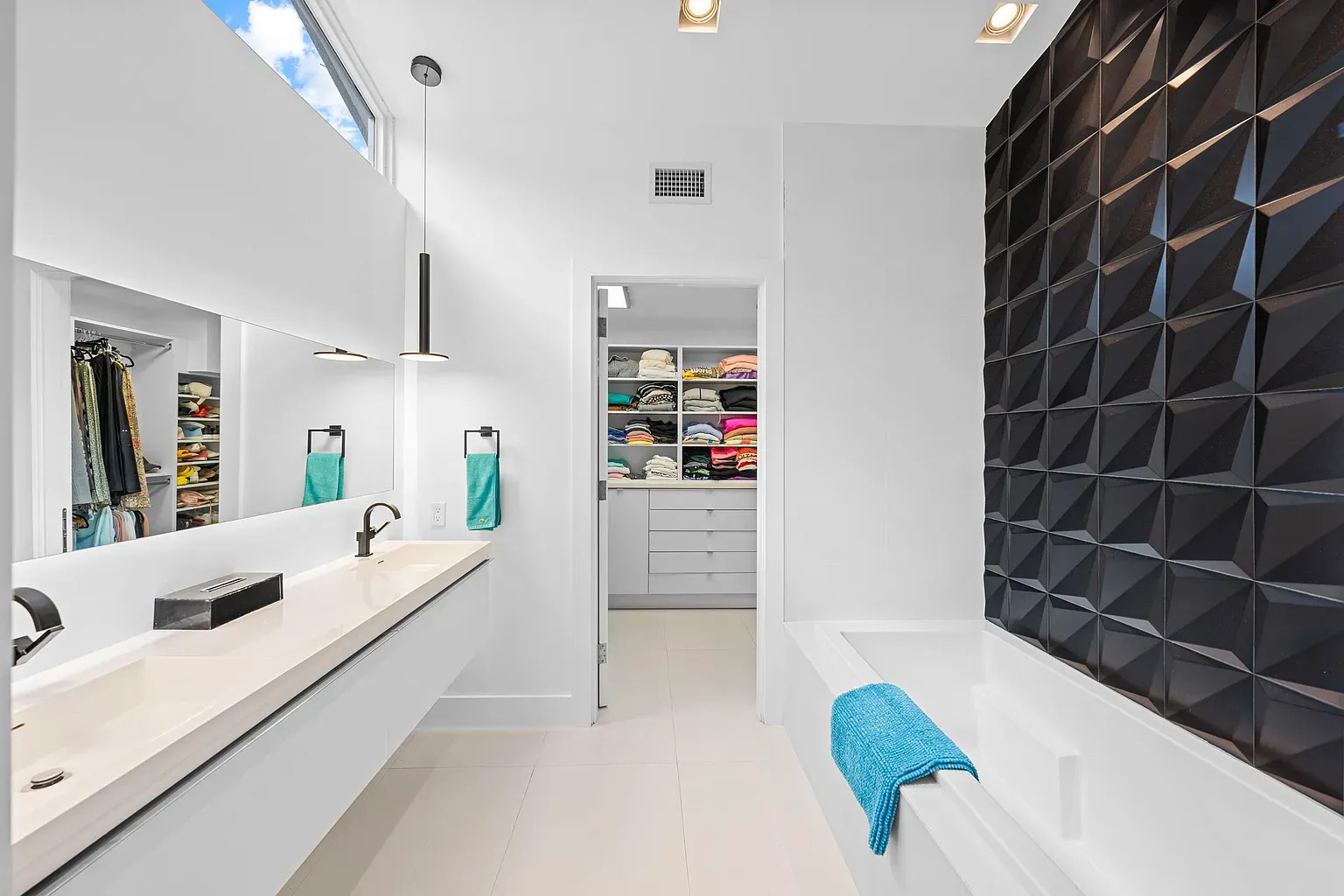 Bathroom glam. twin mirrors, warm pendants, matte black faucet doing the most.