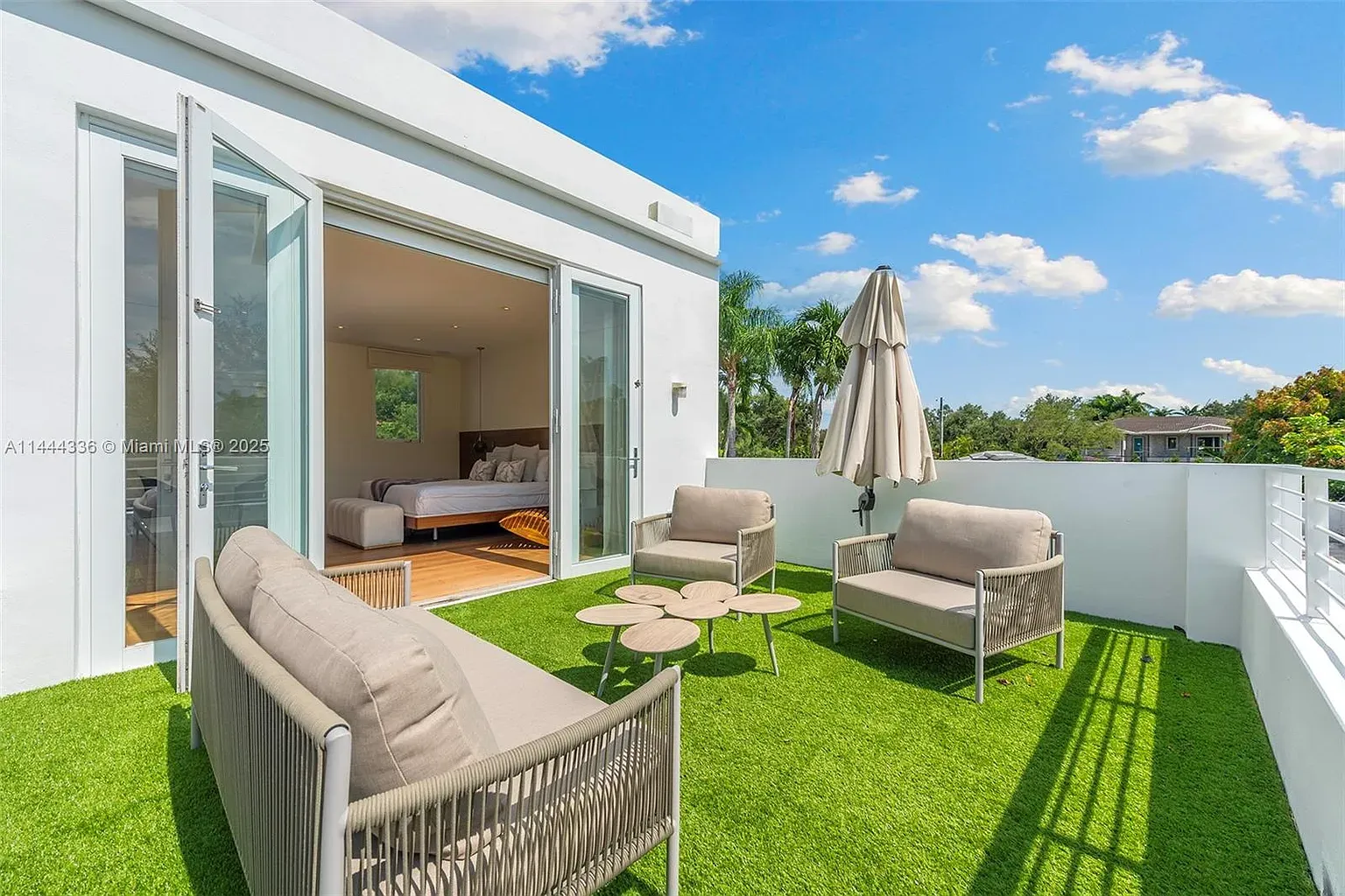 Balcony with emerald turf and low sofas. Anyone know why they chose turf?