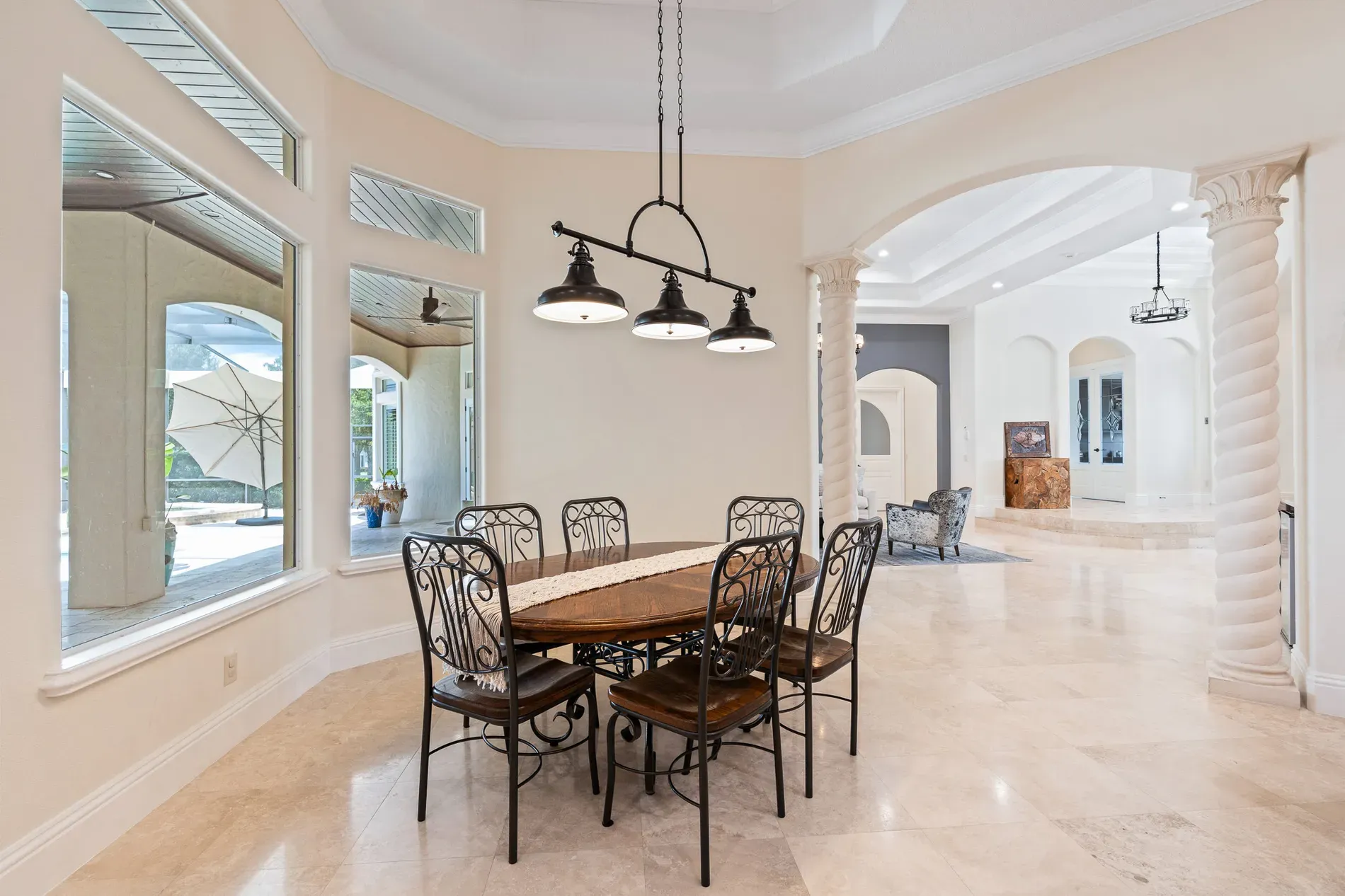 Dining area with the iron chairs. Rustic table, cool chandelier cluster.