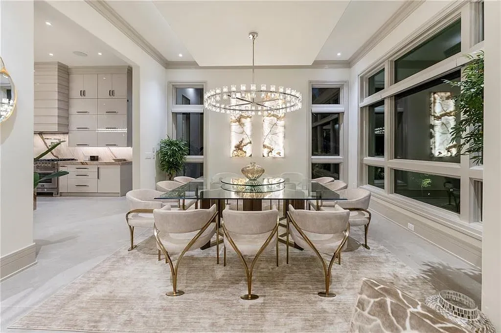 Okay, dining shot from the side — glass table, crystal glow, creamy chairs.