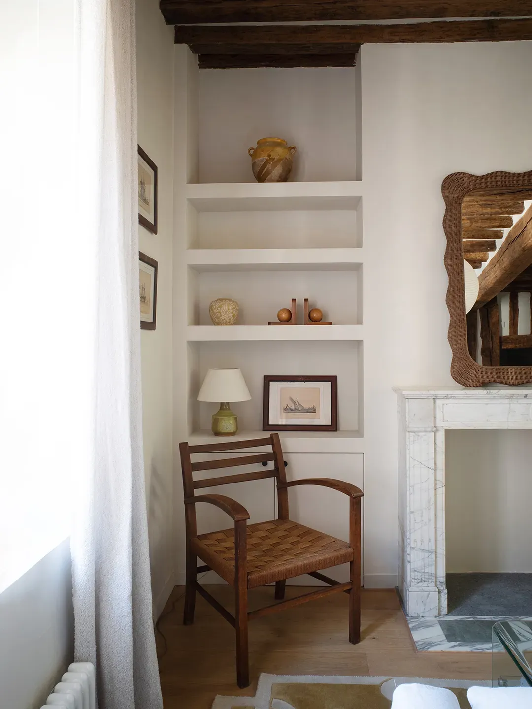 Little reading nook vibes — beams overhead, off-white walls, handcrafted side table tucked left.