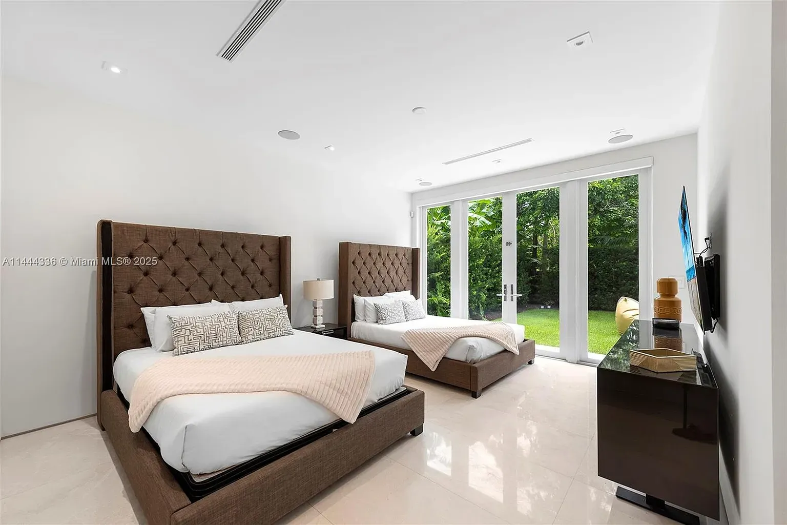 Double beds with tall chocolate headboards. Hotel vibes, but cozy.