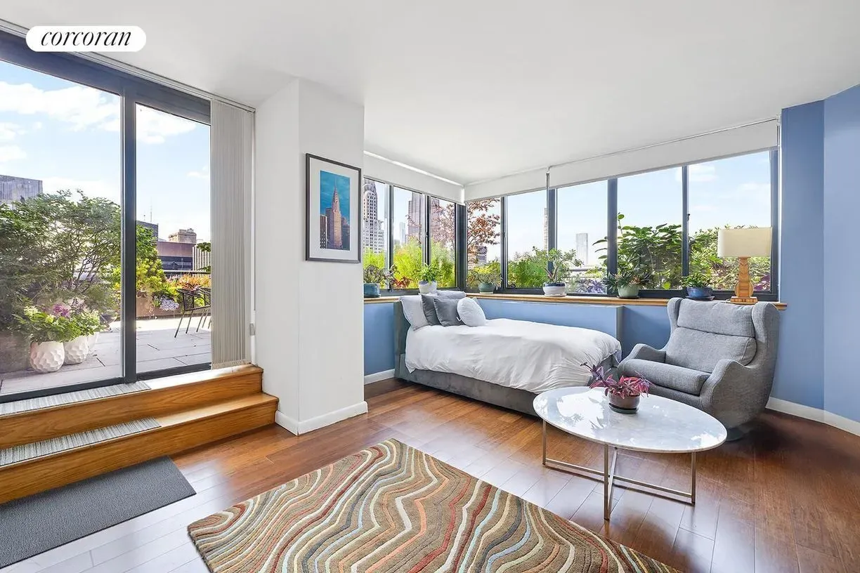 Another bedroom, huge windows. Rugs trying to corral the echo-y wood floors.