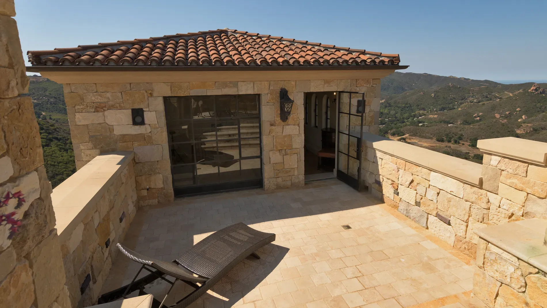 Terrace with chunky stone walls in sandy tones. It blends nicely, honestly.