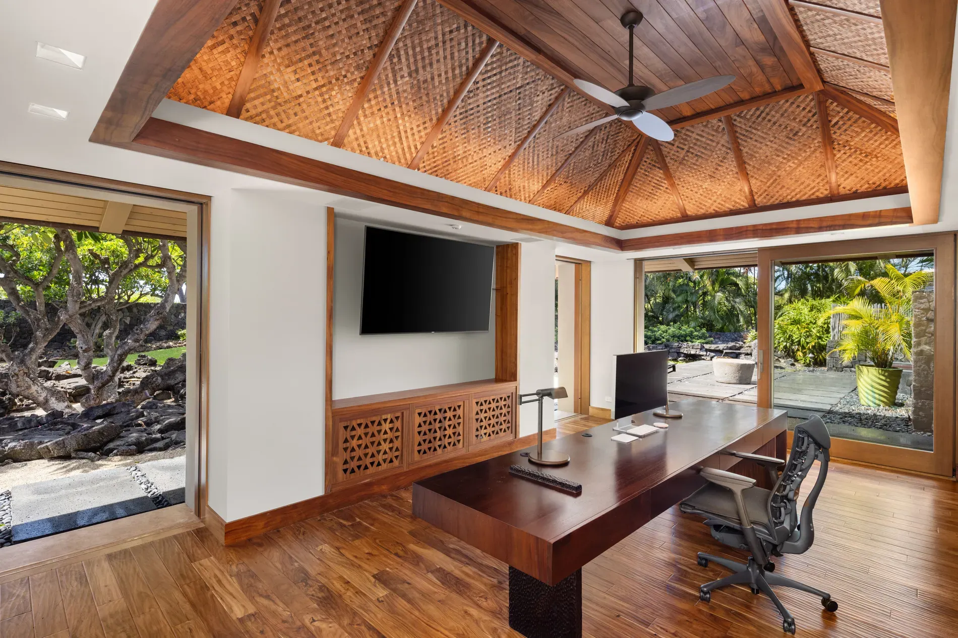 Here's the office — bamboo coffers overhead, big desk, jungle peeking in.