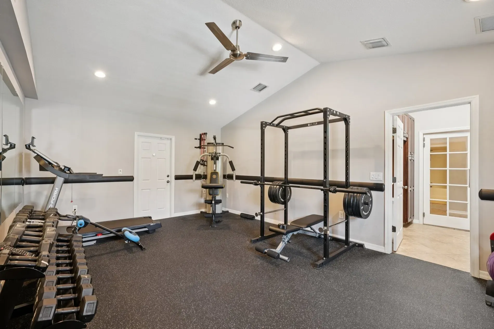 Gym with sloped ceilings and a full mirror wall. Feels bigger instantly.
