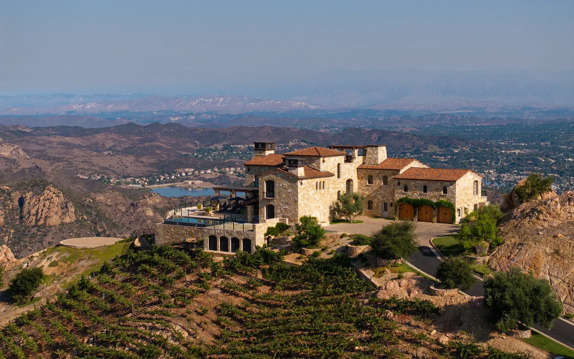 Another hillside estate, earthy stone and terracotta, tucked into those rolling hills.