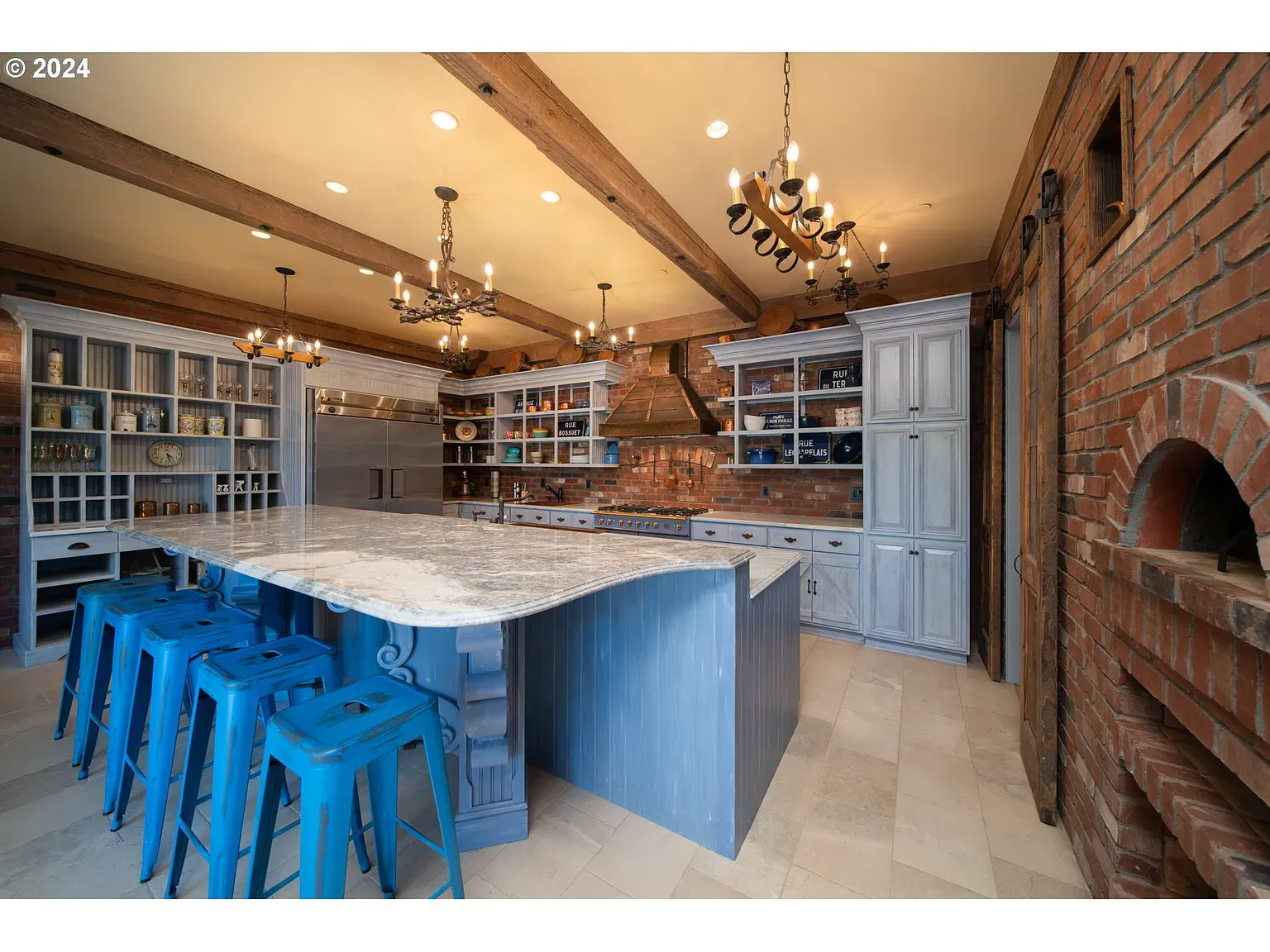 Curved marble island for days. Bright blue stools—anyone know why this bright?