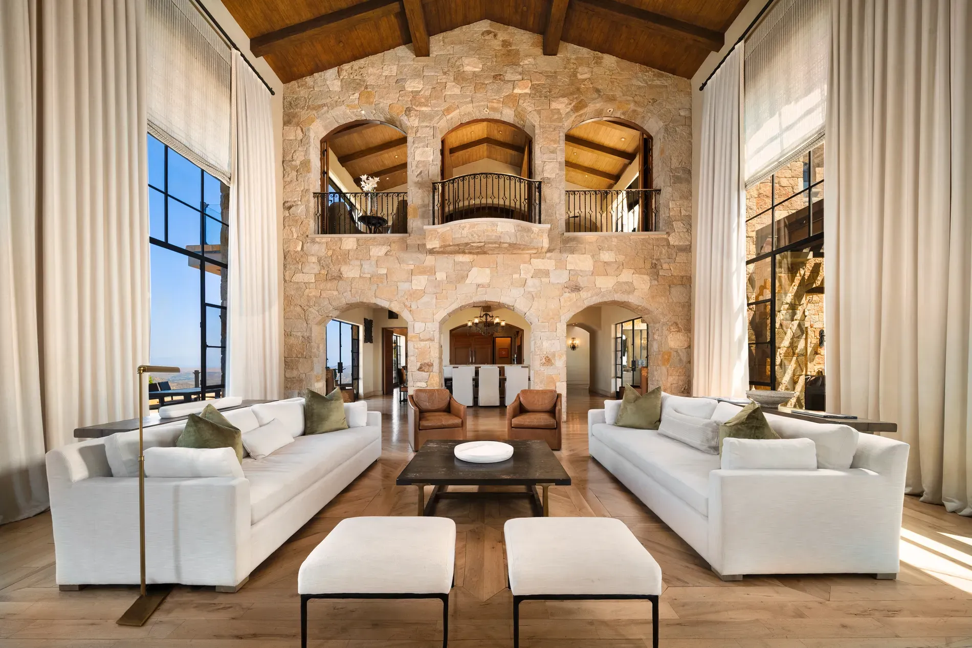 And then the great room—stone walls, huge beams, arched windows pulling views.