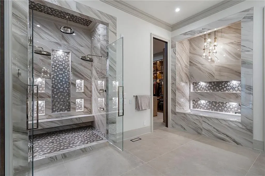 Glass box shower with marbled walls. Looks spa-level. Maybe slippery?