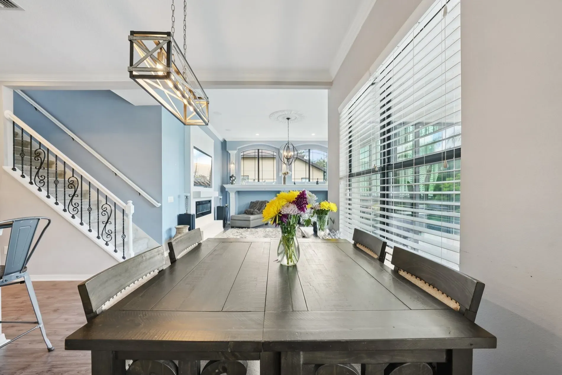 Open dining to living. Rustic table meets cozy sofa—good balance, great hangout.