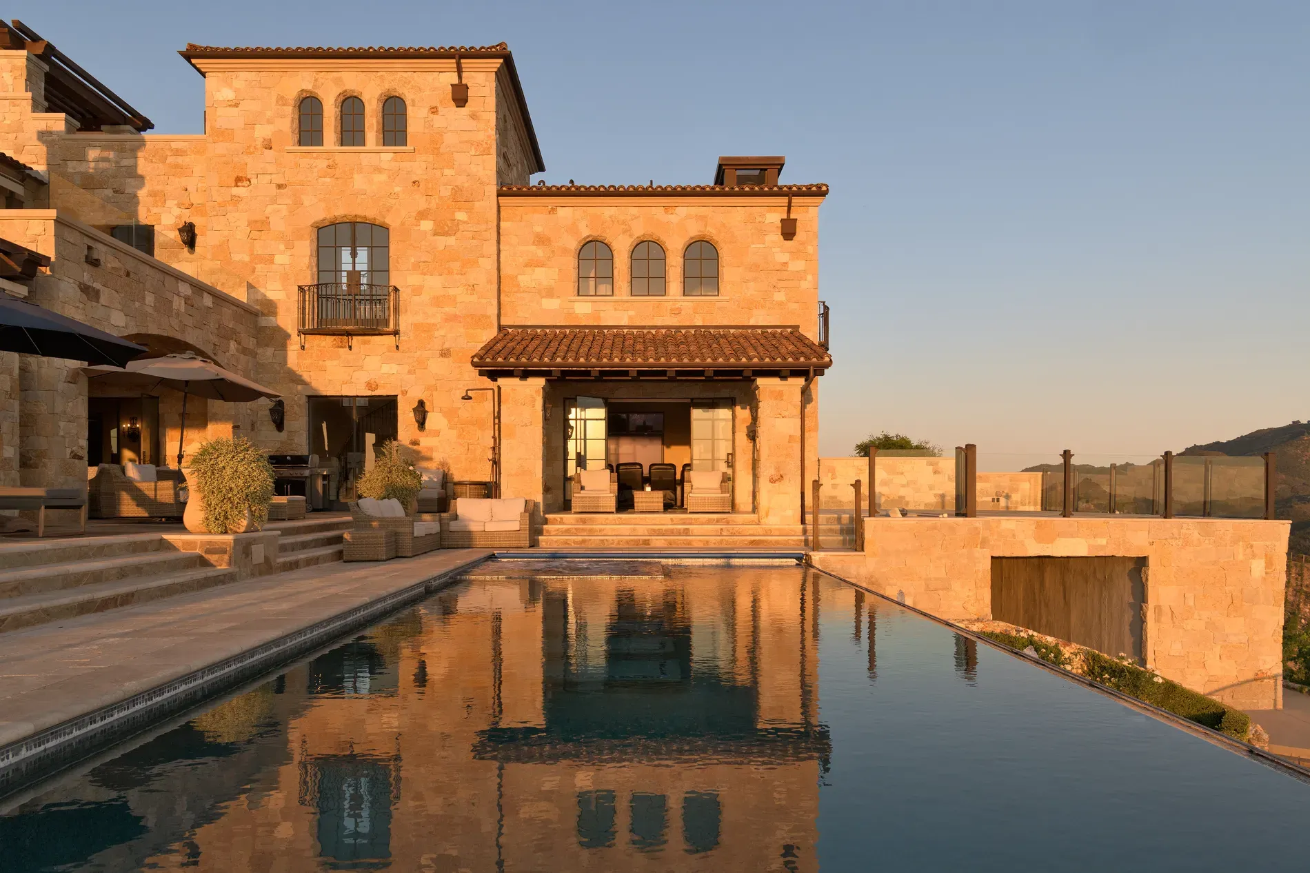 Golden-stone villa catching sunset. Arched doors everywhere—maybe one arch too many?