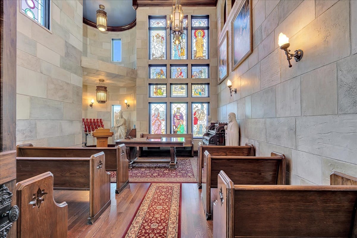 Small chapel energy. Warm stone, stained glass rainbows. Kinda peaceful, kinda theatrical.