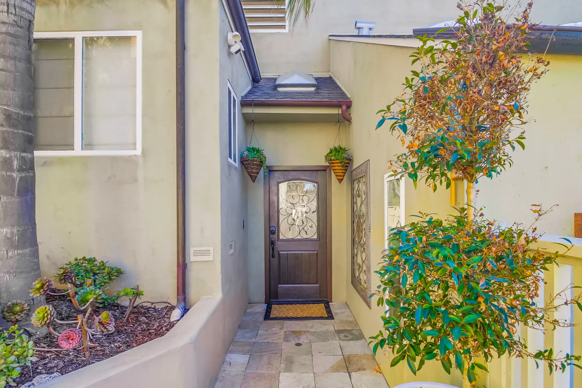 Soft beige stucco, huge windows, and a wood-trimmed door. Simple and warm.