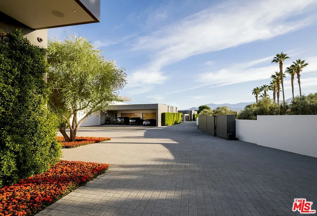 Long stone drive up to a glassy front—clean, open, very composed.