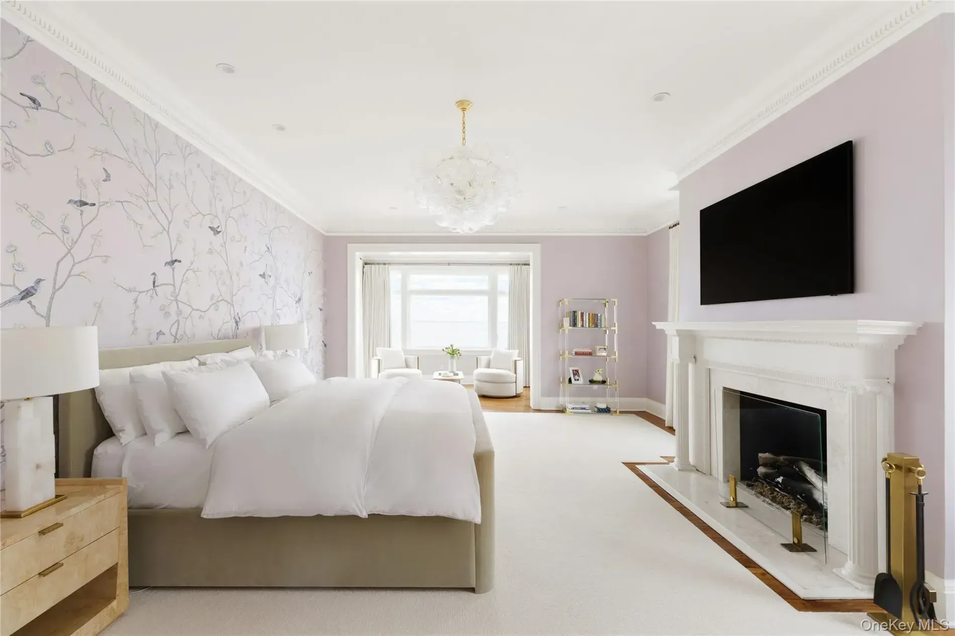 Soft purple wallpaper with little birds. Hotel-level bed situation.