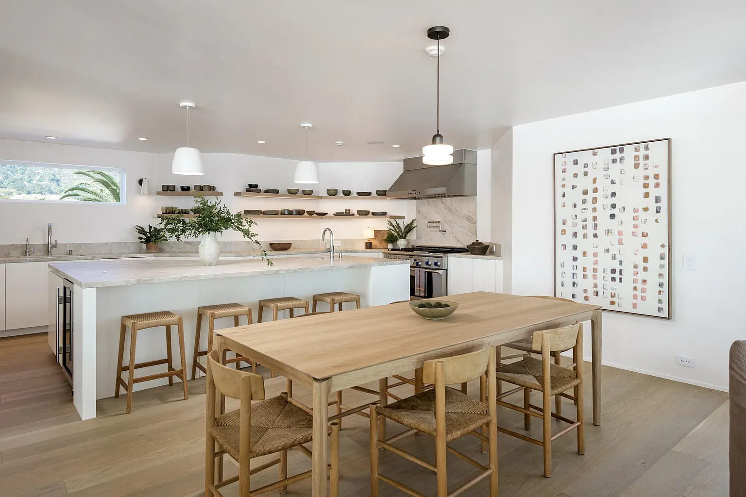 Open kitchen and dining, bright stone island, feels morning coffee central.