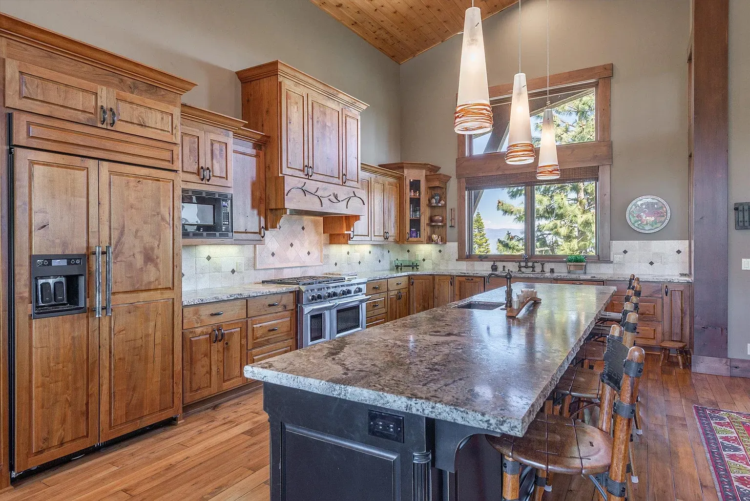 Kitchen leans classic. honey cabinets, chunky hardware, big slab of granite.