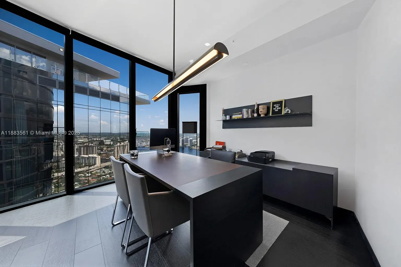 Here's the office — floor to ceiling glass. White walls, clean desk, productive.