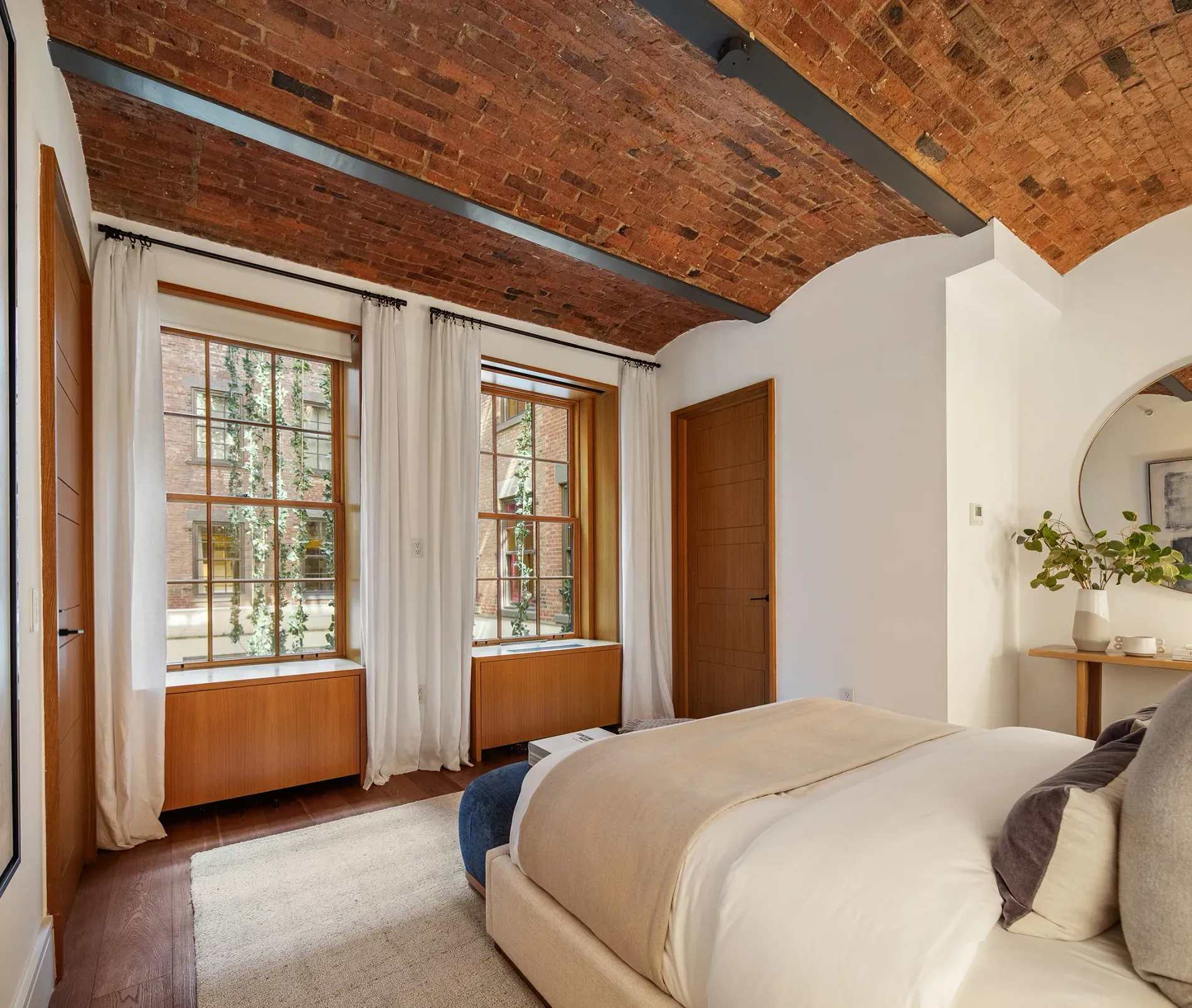 Arched brick ceiling over a cozy bed. Love the windows. wood frames slap.