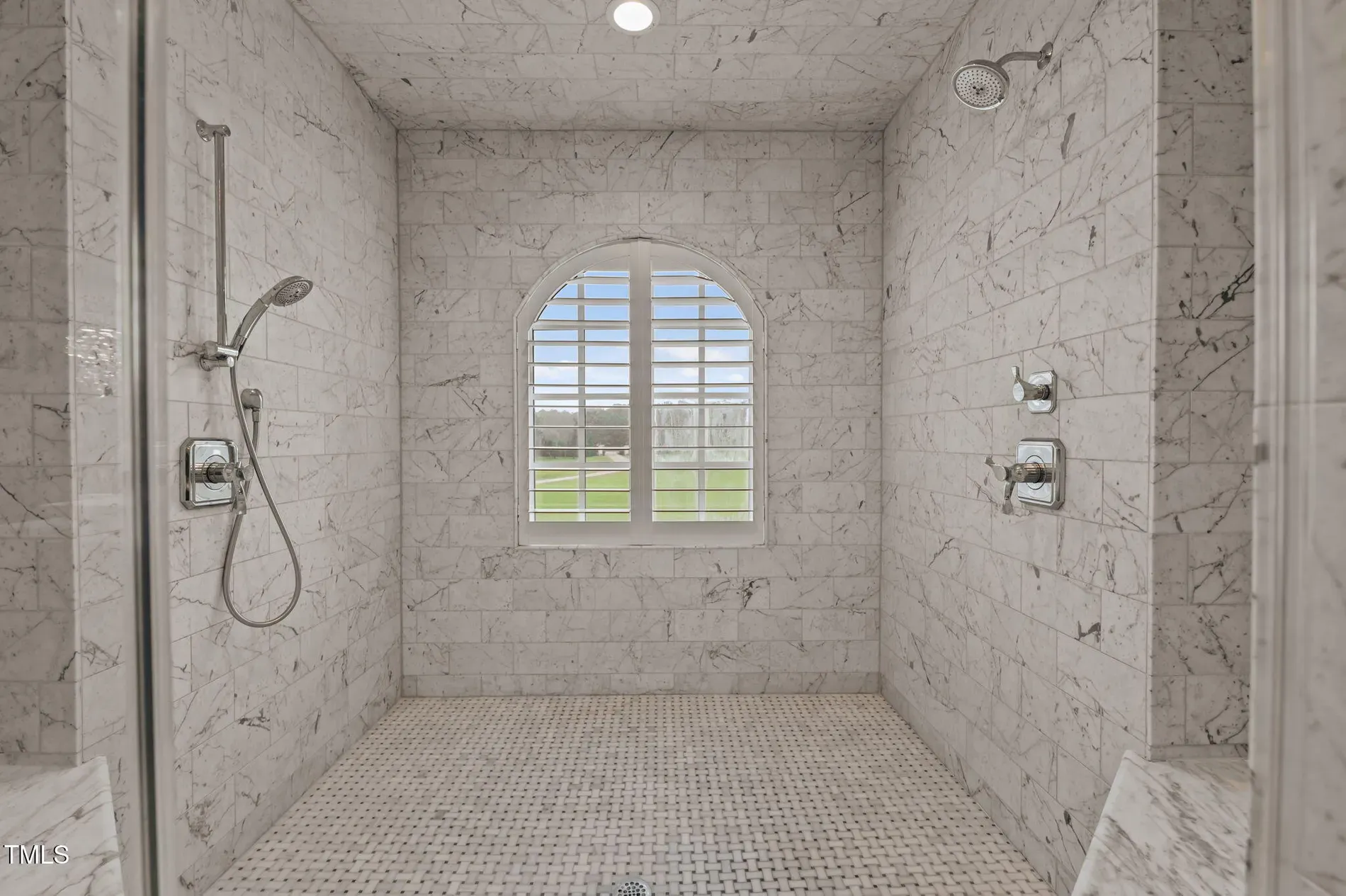 Walk-in shower a gallery. Marble slabs, little arch detail—nice touch.