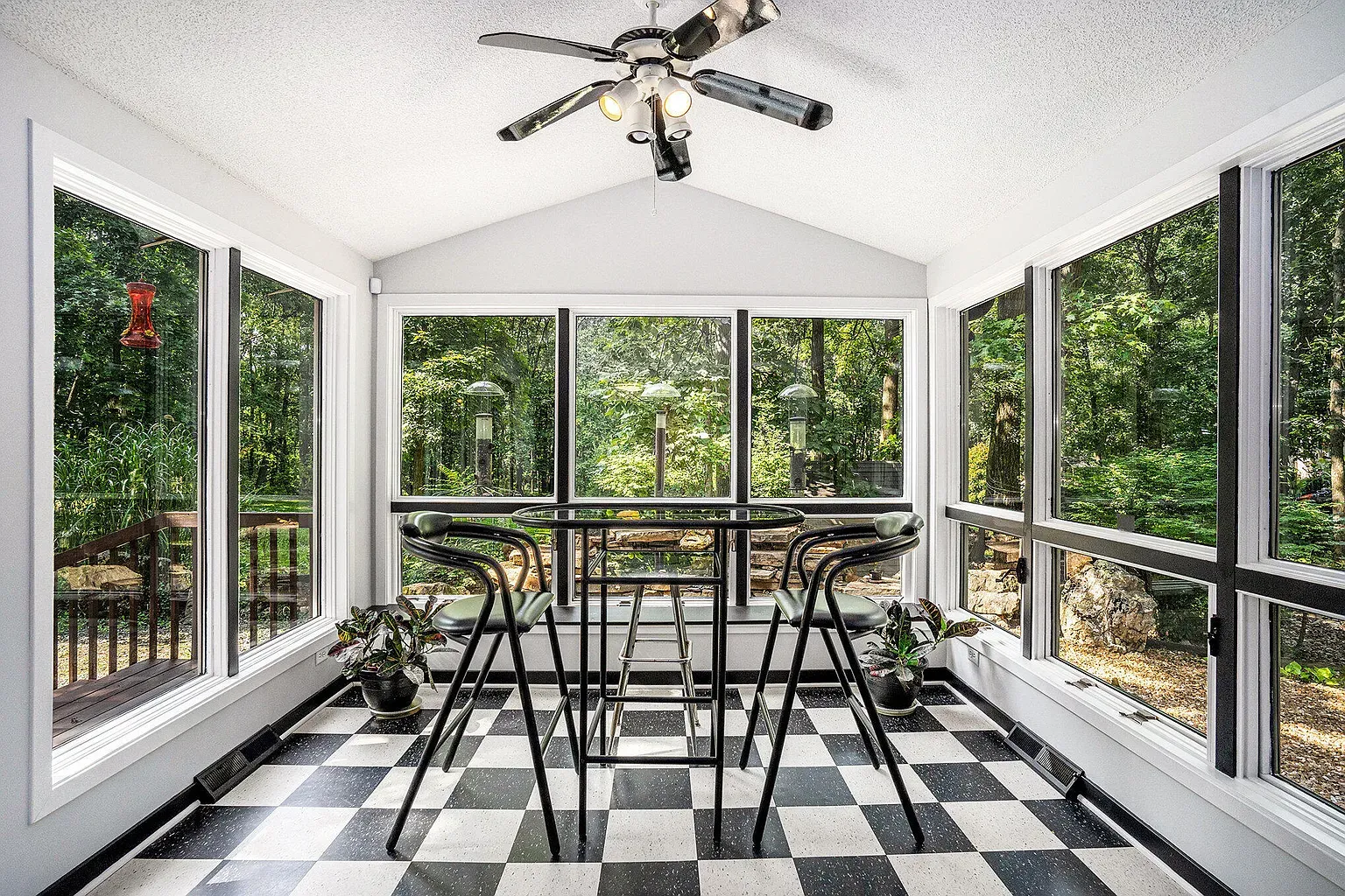 Sunroom just glass and trees. I’d drink coffee here forever.