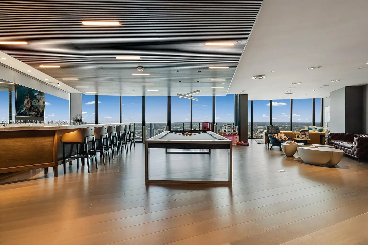 Penthouse shot. open, bright, warm wood floors. City skyline doing the heavy lifting.