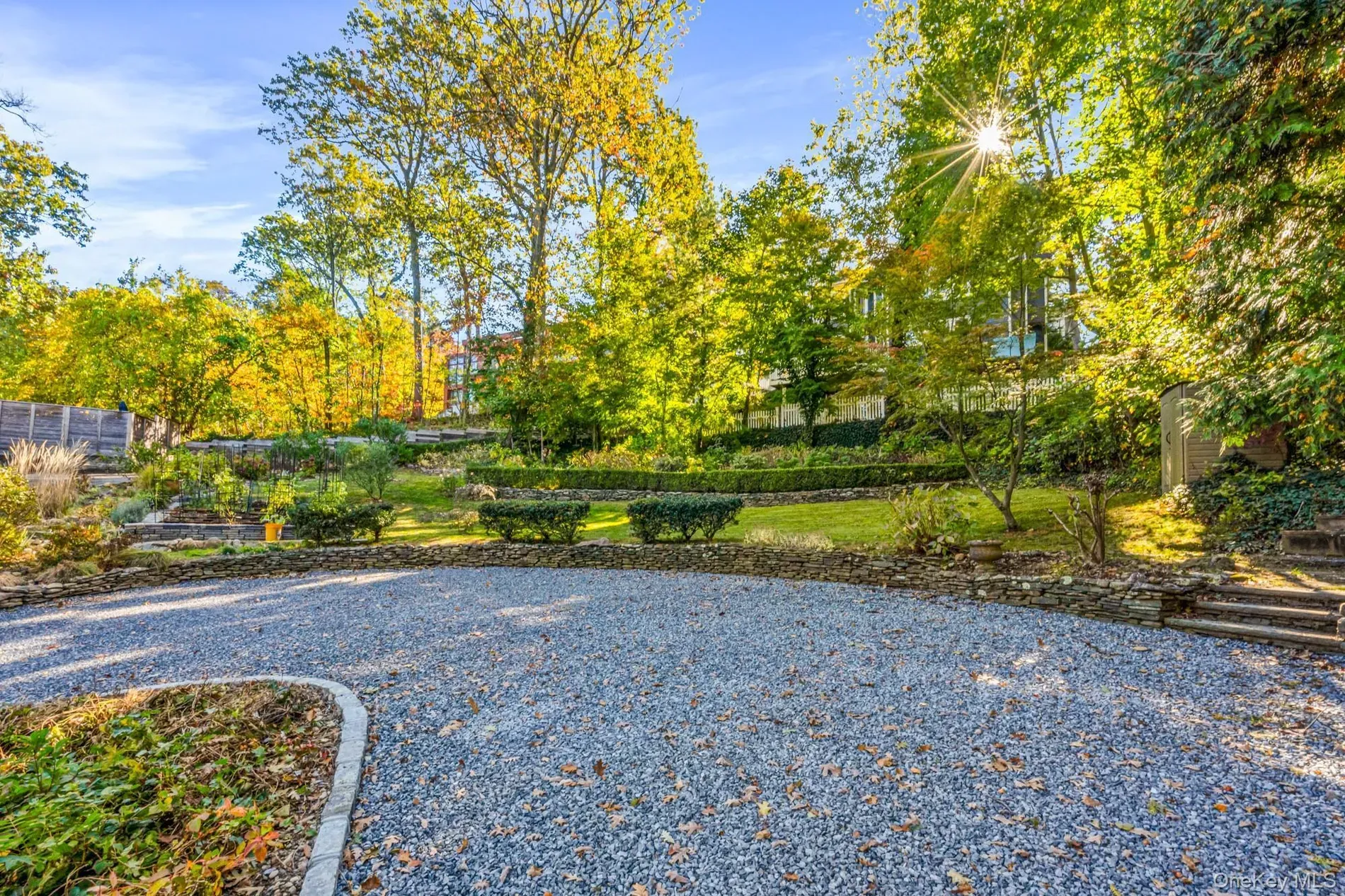 Pebble driveway into a leafy garden. fall colors doing their thing.