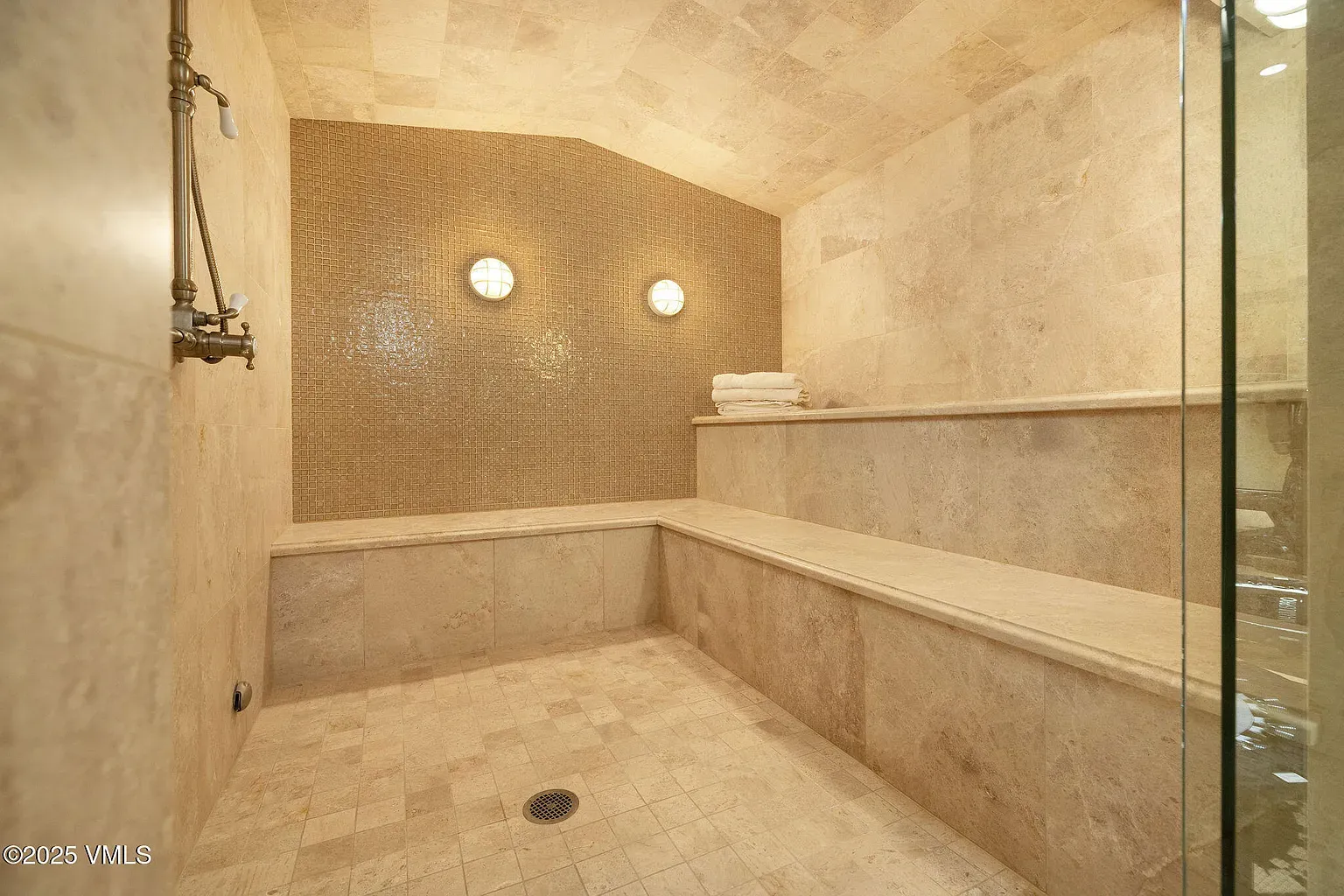 Steam shower with gold tile glow. Kinda glam, kinda cave.