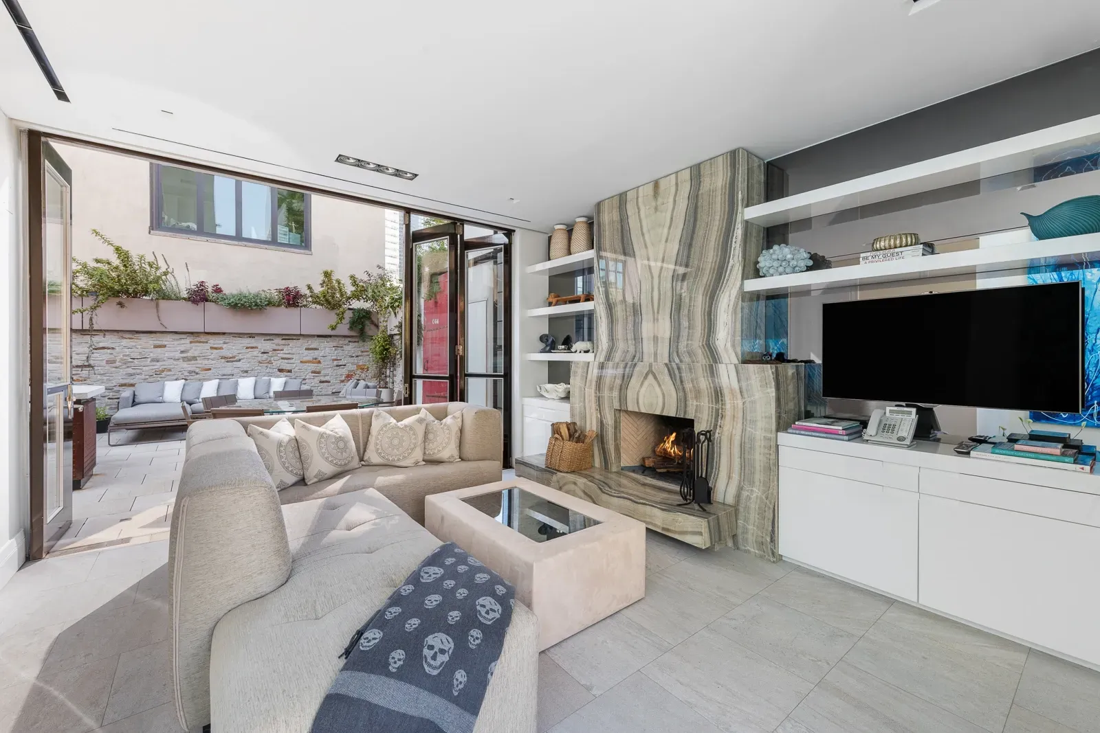 Minimal living area, veined stone fireplace, doors open straight to the yard.