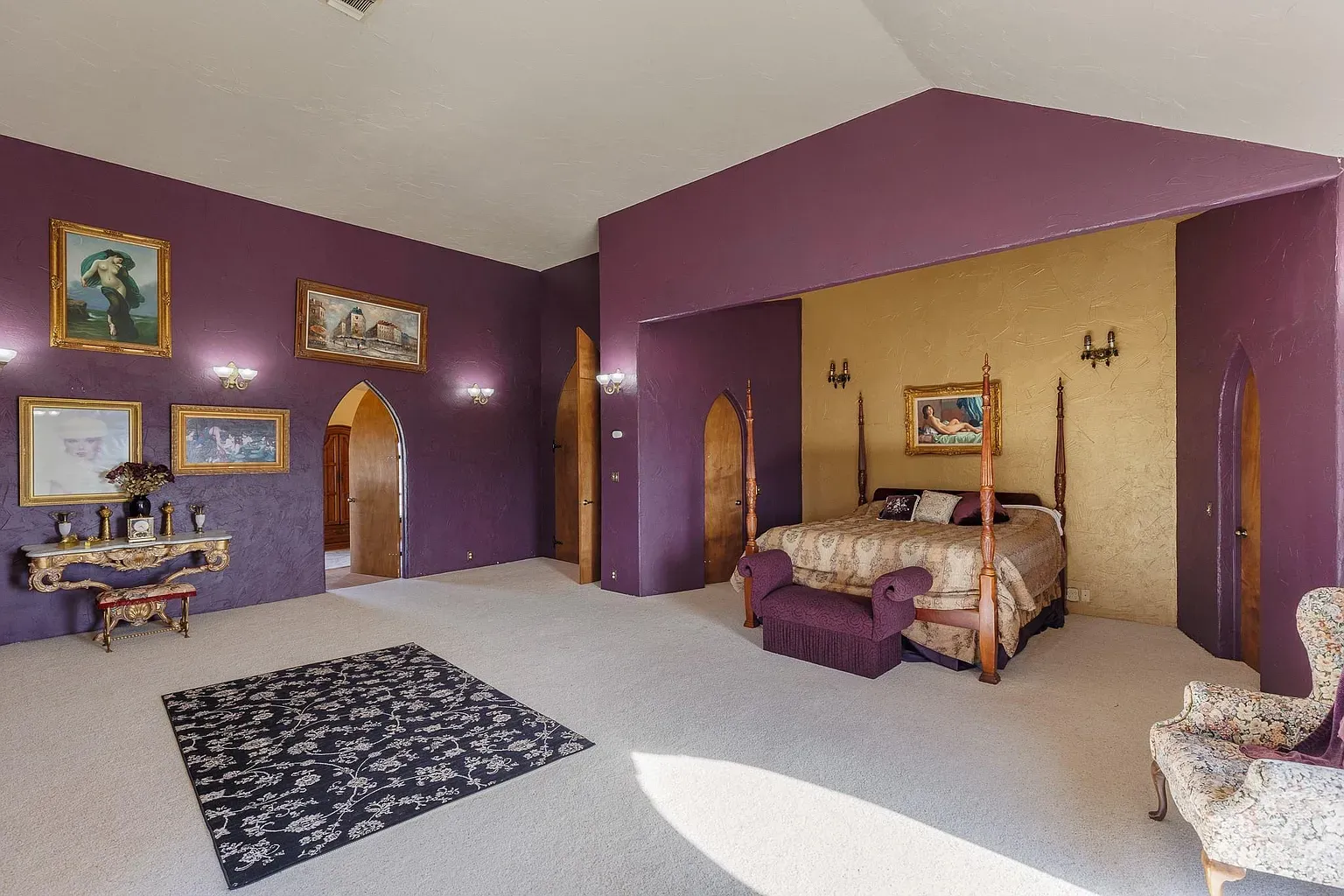 Purple bedroom goes full royal. Soft lighting keeps it from feeling heavy.
