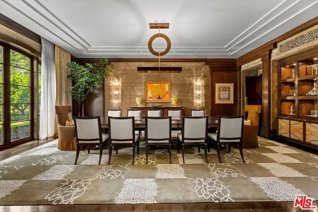 Walnut-paneled dining room and a statement chandelier. Formal without feeling stiff.