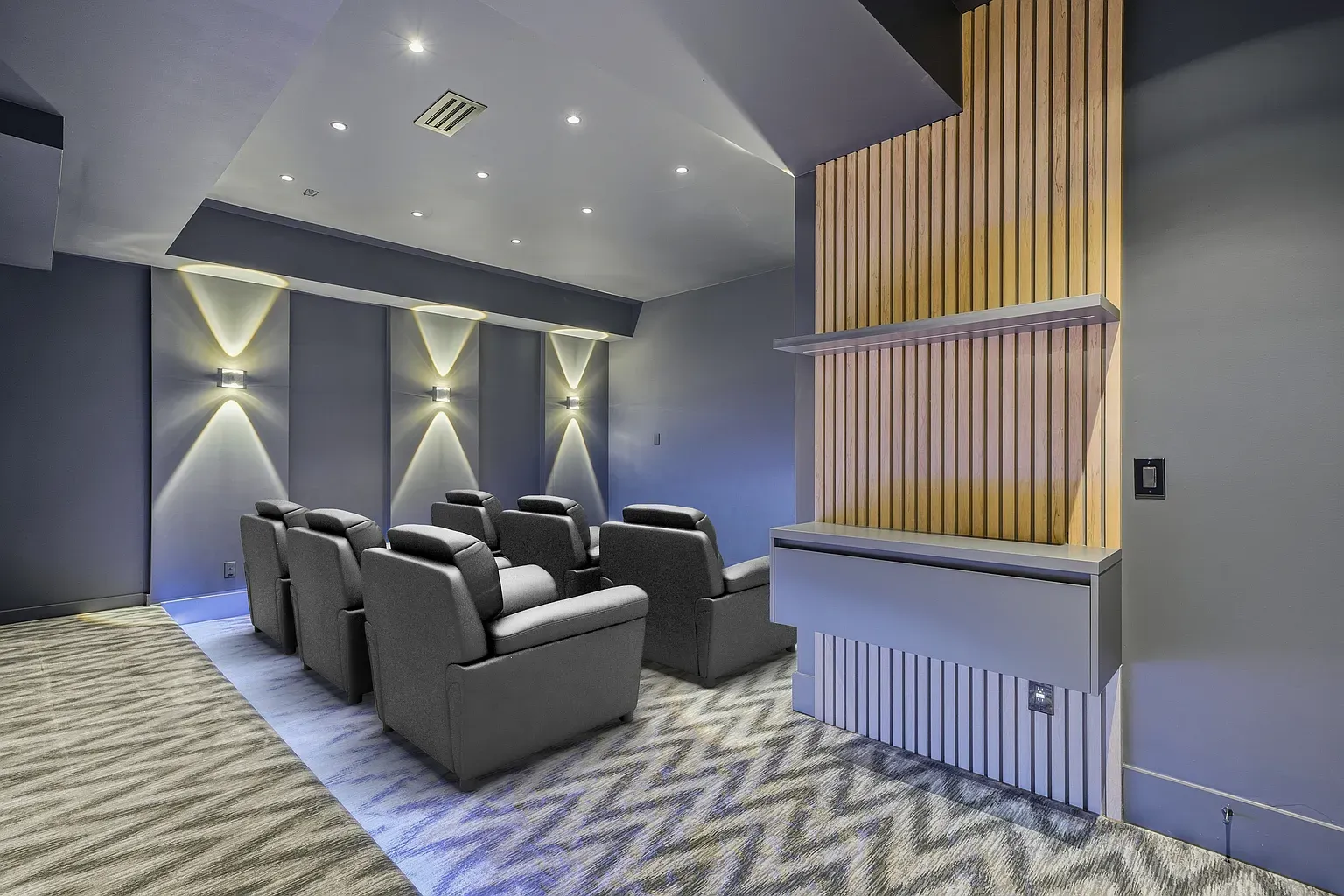 Home theater time. Recliners lined up, dark walls, no glare, just snacks.