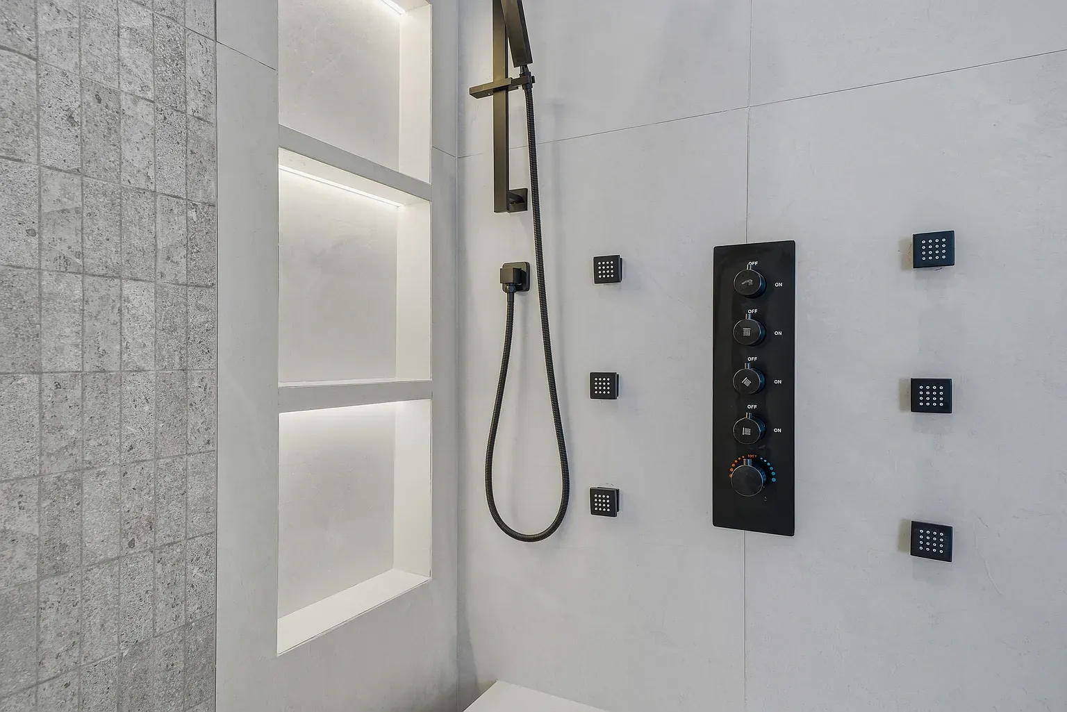 Ceiling-mounted rain shower is fancy. Big gray tiles keep it calm.