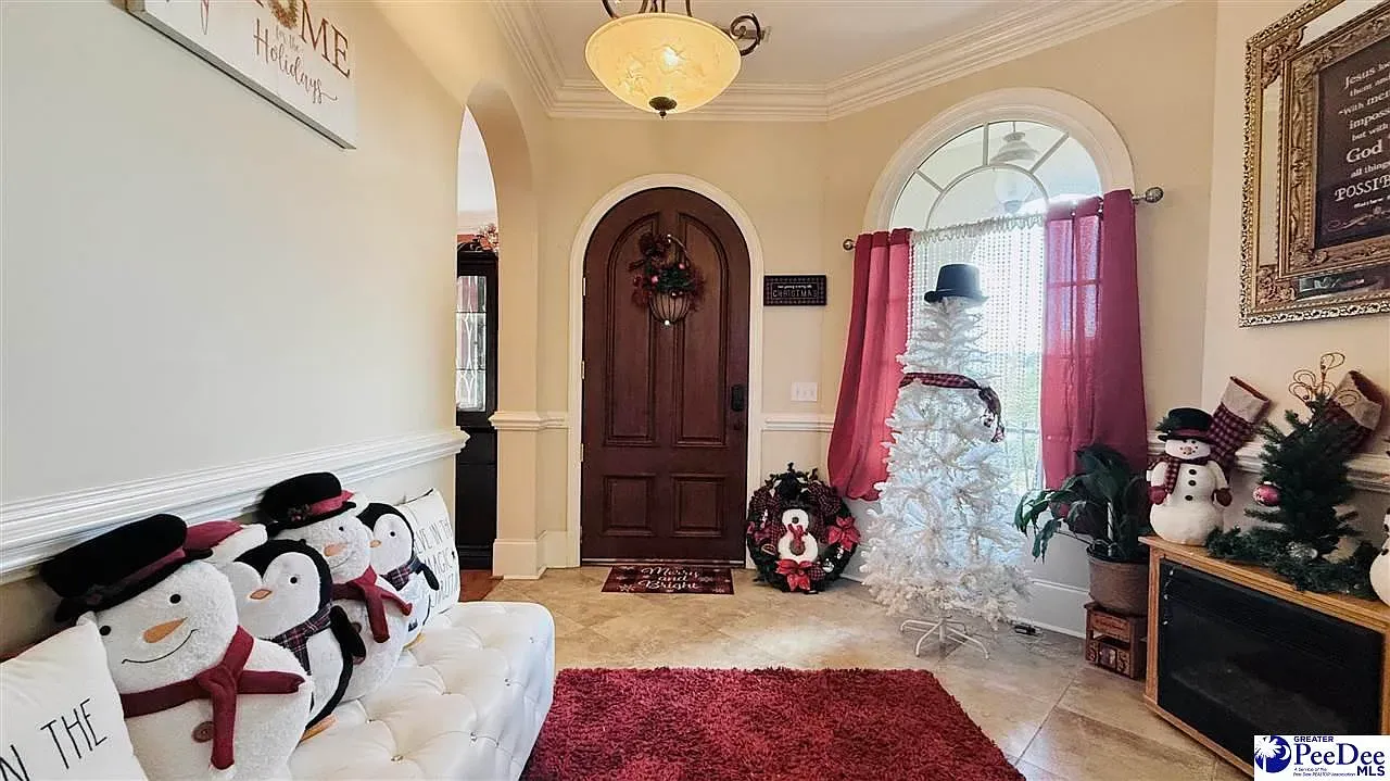 Foyer doubles as holiday postcard—dark wood door, big round detail, twinkle lights.