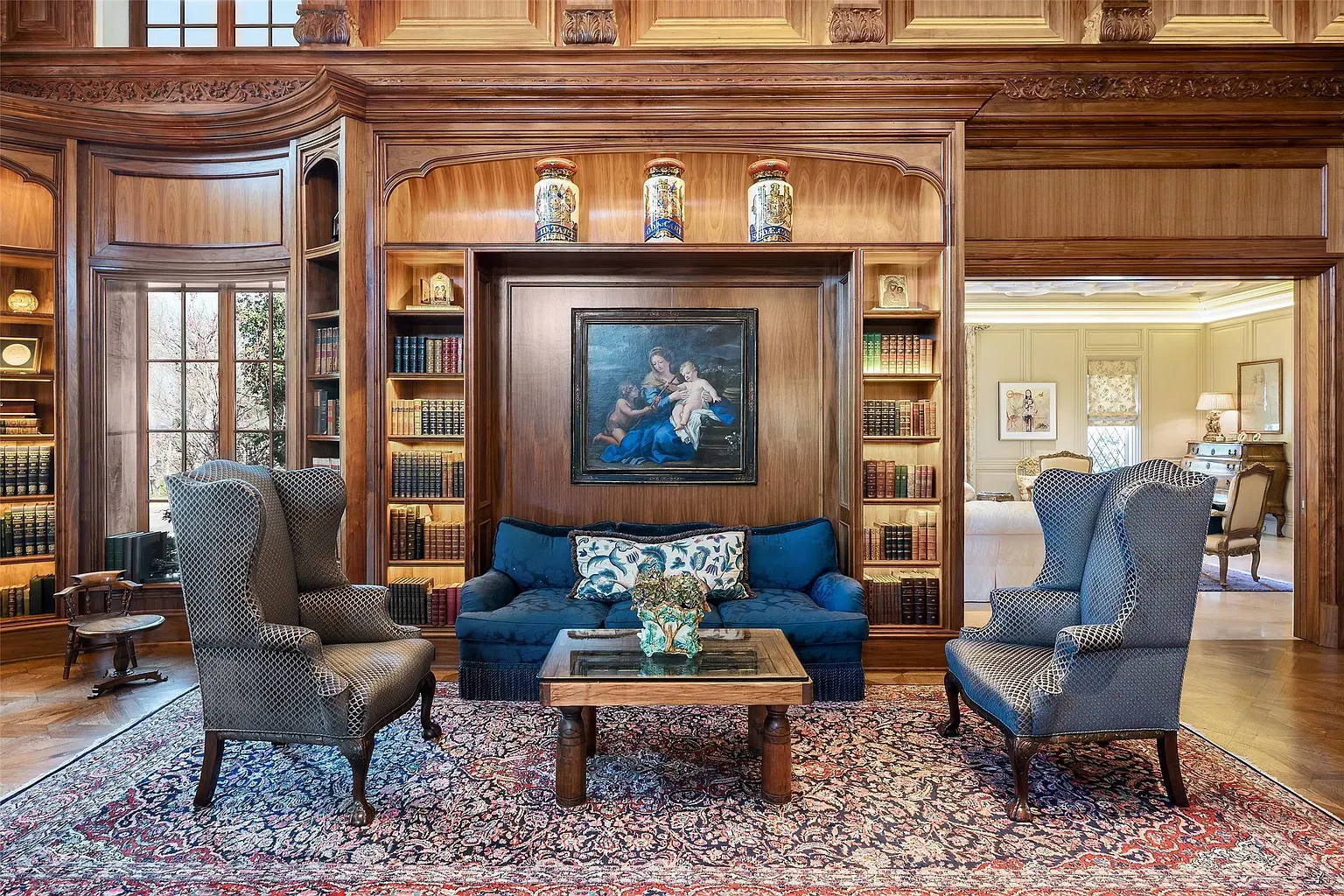 Wood-paneled library, deep blue velvet sofa, pillows trying their best.